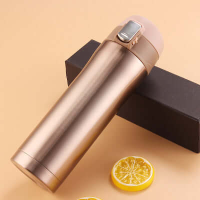 Premium insulated travel mug in bronze color with a black box and lemon slices, ideal for coffee and tea.