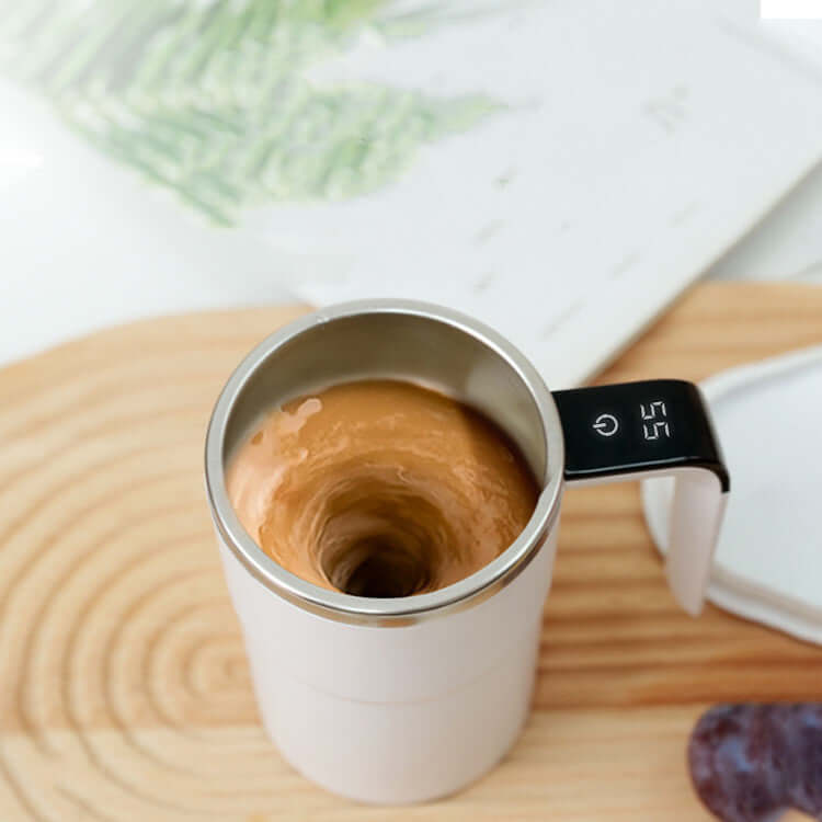 Top view of a USB rechargeable electric coffee mug with automatic stirring; coffee swirling inside.