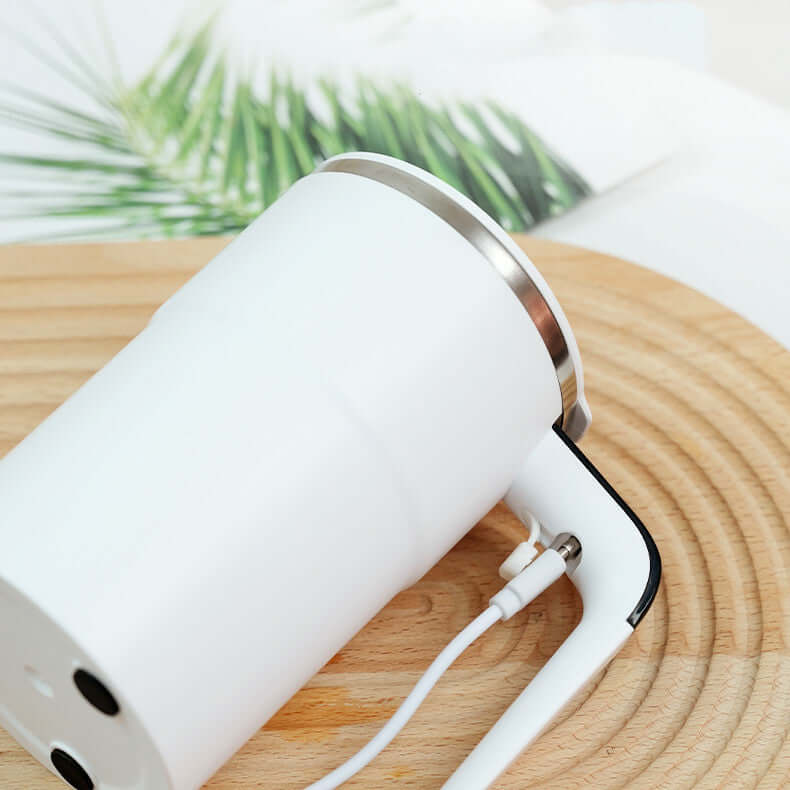 Close-up of a USB rechargeable electric coffee mug with sleek design on a wooden surface.
