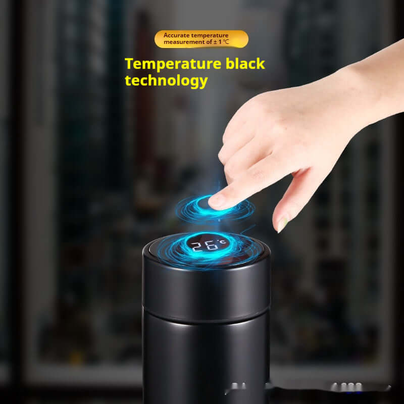 Close-up of hand using smart temperature display on insulated bottle, showing temperature technology and sleek design.